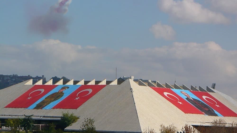 Atatürk Kültür Merkezi yerleşkesindeki basamaklı beton çatılı yapı; çatıya Türk bayrakları ve Atatürk portreleri asılı