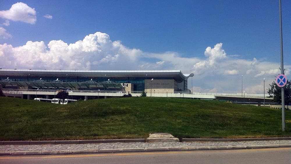 Esenboğa Havalimanı terminal binası, yol kenarındaki çimenli bayırın ardından görünüyor